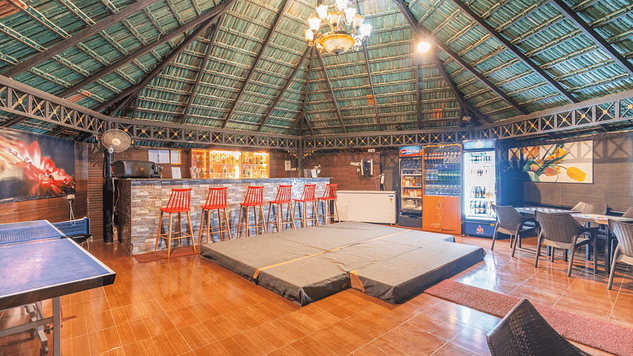 A bar with a chandelier on the ceiling at Coorg Jungle Camp Backwater Resort, Kushalnagar.