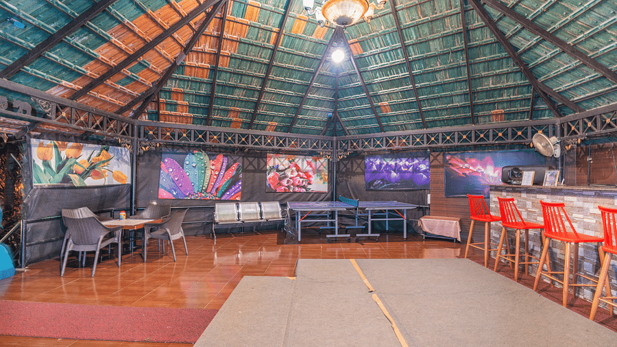 Image of a bar with high chairs and a sitting area in the corner at Coorg Jungle Camp.