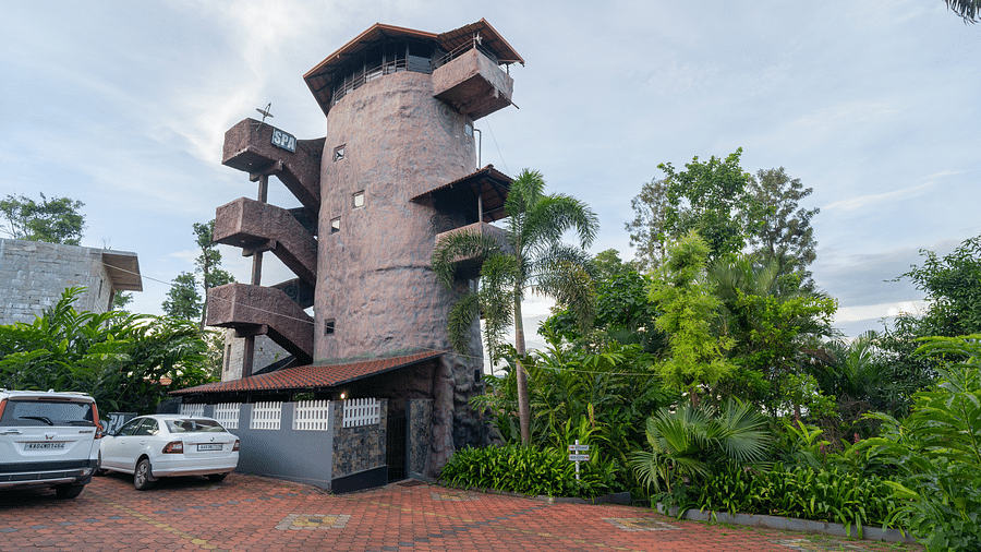 Facade of an accommodation with trees on the side at Coorg Jungle Camp.