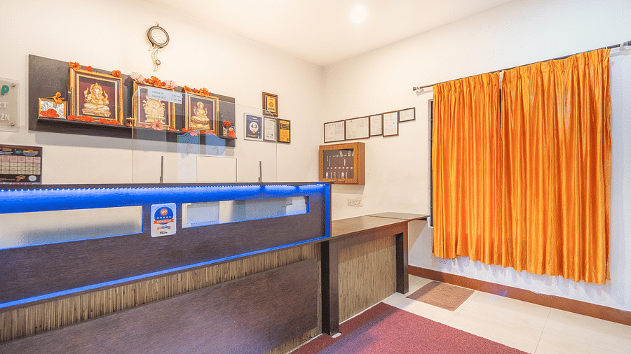 A reception area with a table with a window on the side at Coorg Jungle Camp Backwater Resort, Kushalnagar.