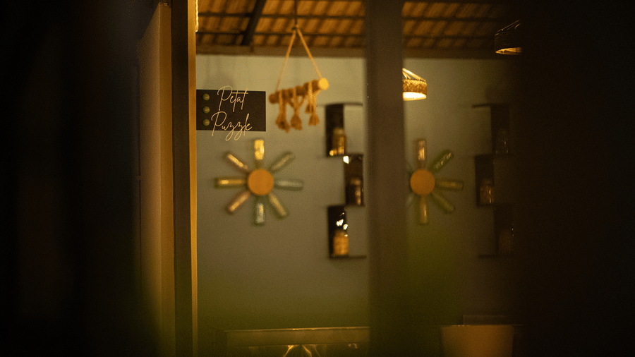 Warmly lit dining interior featuring decorative wall mirrors, wooden shelving, and ambient yellow lighting.