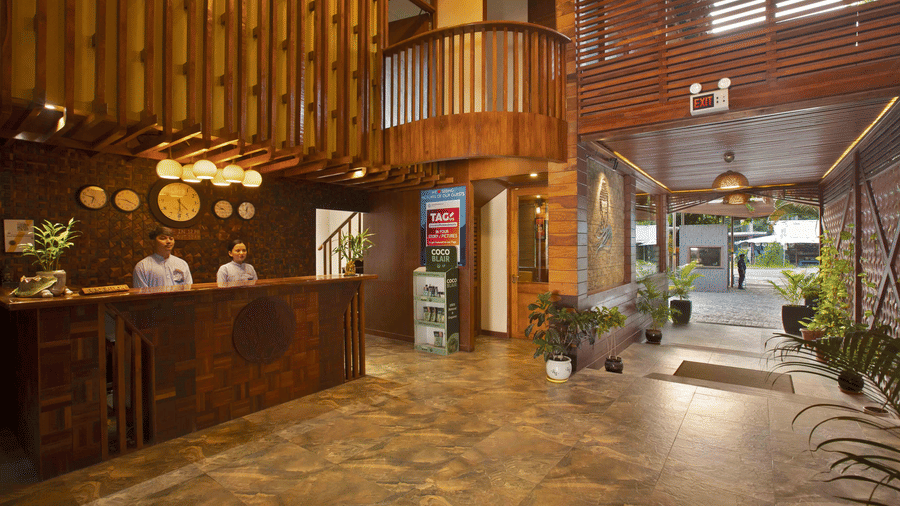 Two women standing at a reception with fancy lights and multiple clocks showing the different times around the world