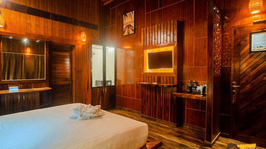  peaceful hotel room with a wooden interior, featuring a bed and stylish lighting fixtures. The design is simple yet elegant, with a relaxing vibe.