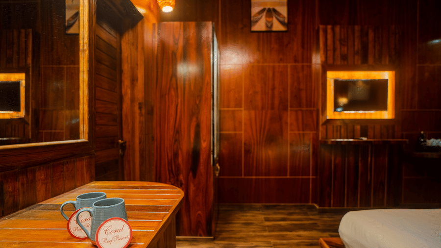 A warm, wooden room with a comfortable bed, stylish lamps, and soft ambient lighting. The simple yet elegant decor creates a peaceful atmosphere.