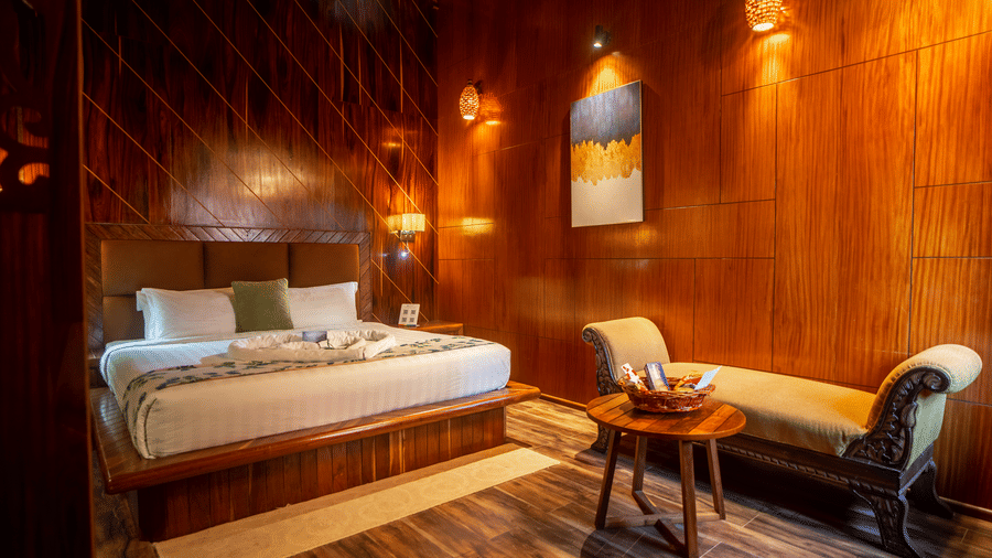 A wooden room with ambient lighting, a comfortable chair, and a small wooden table with decorative items. The modern design blends seamlessly with the natural wooden walls.