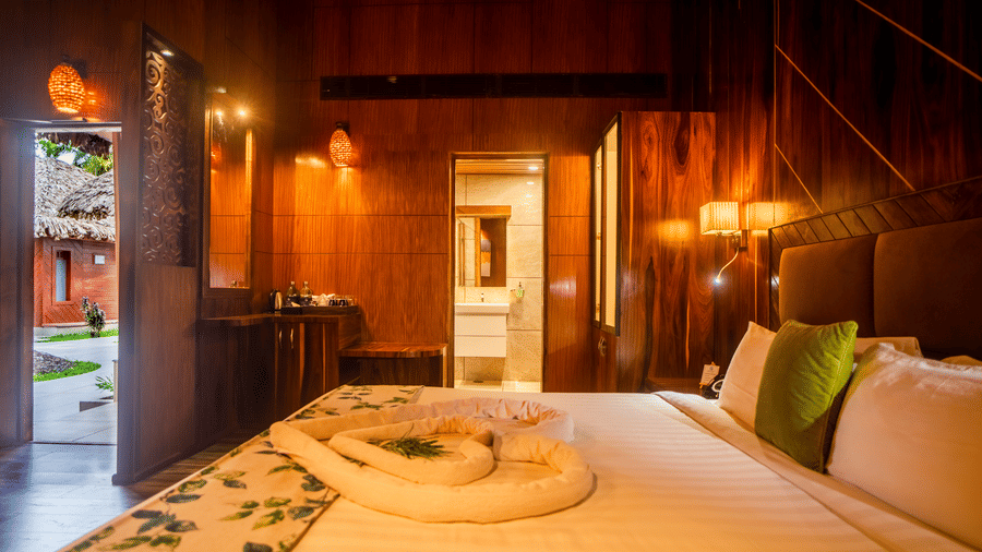  A spacious room with a large bed, wooden walls, and soft lighting. The room features comfortable seating and a modern yet rustic design, perfect for a relaxing stay