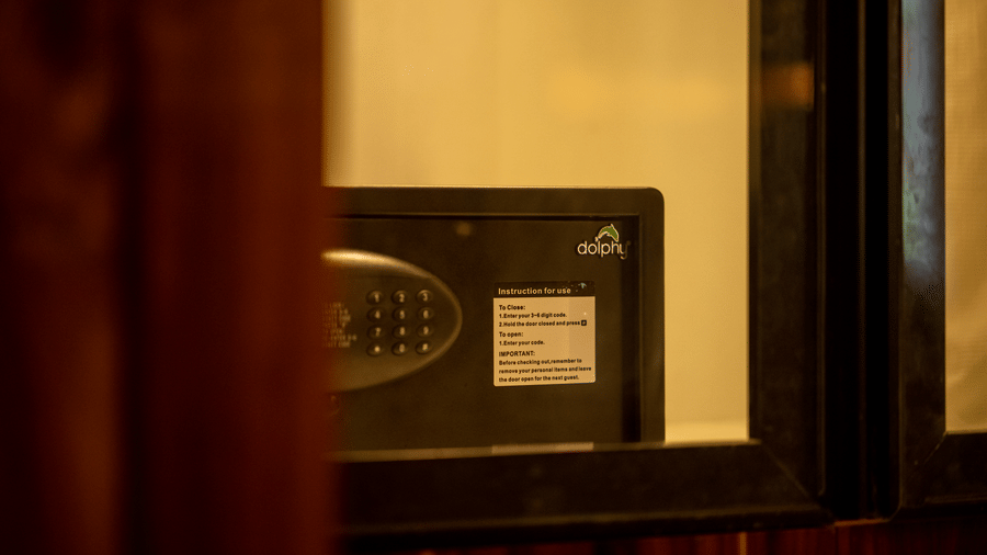  A close-up of a safe inside a wooden cabinet, showing the combination lock on the screen. The setting suggests a secure and private space for guests.