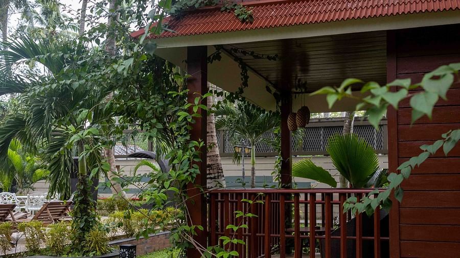 Exterior of red structure with railing bound gates with greens around and garden in the background full of plants and trees - Coral Reef Resort & Spa, Havelock