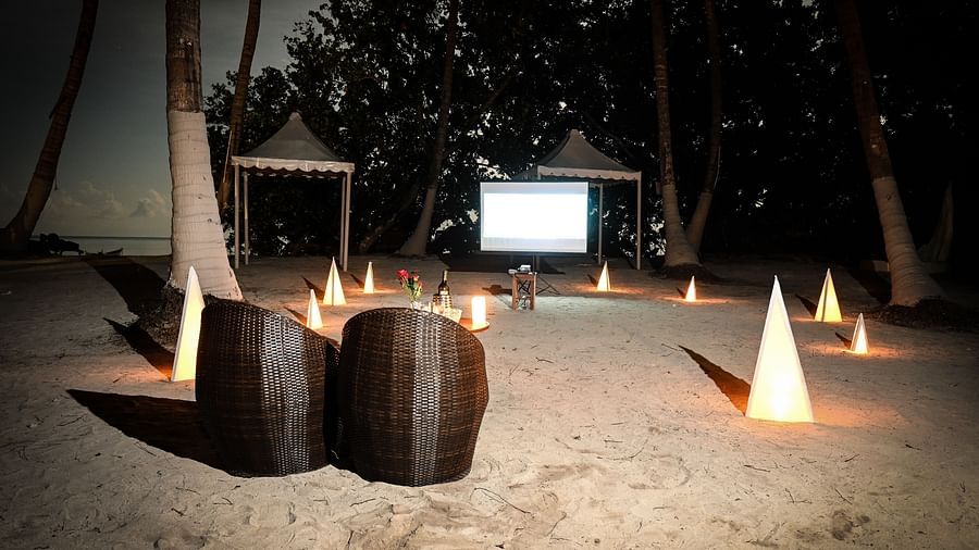 Chairs on the beach with a projector playing on the white screen in the background - Coral Reef Resort & Spa, Havelock