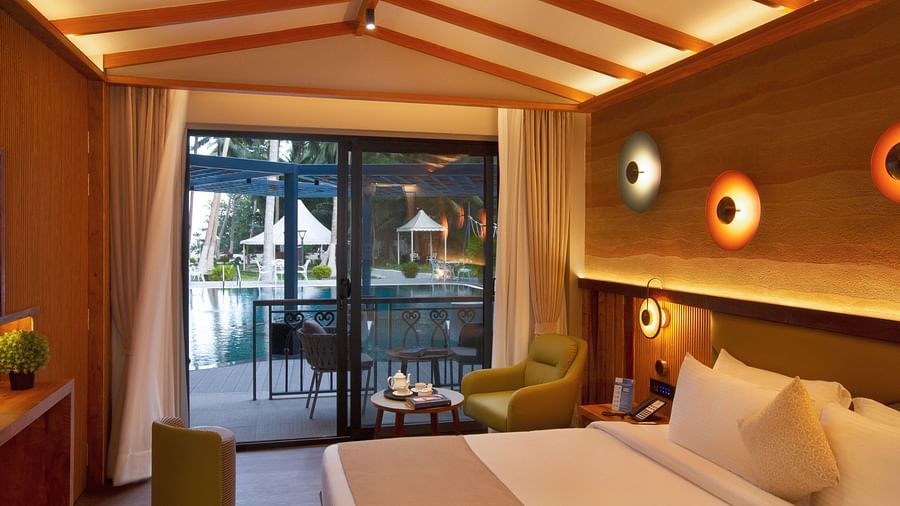 Coral Sapphire at Coral Reef Resort and Spa in Havelock featuring a plush bed and a seating space next to it with the door to the outdoor lounge area beside it  