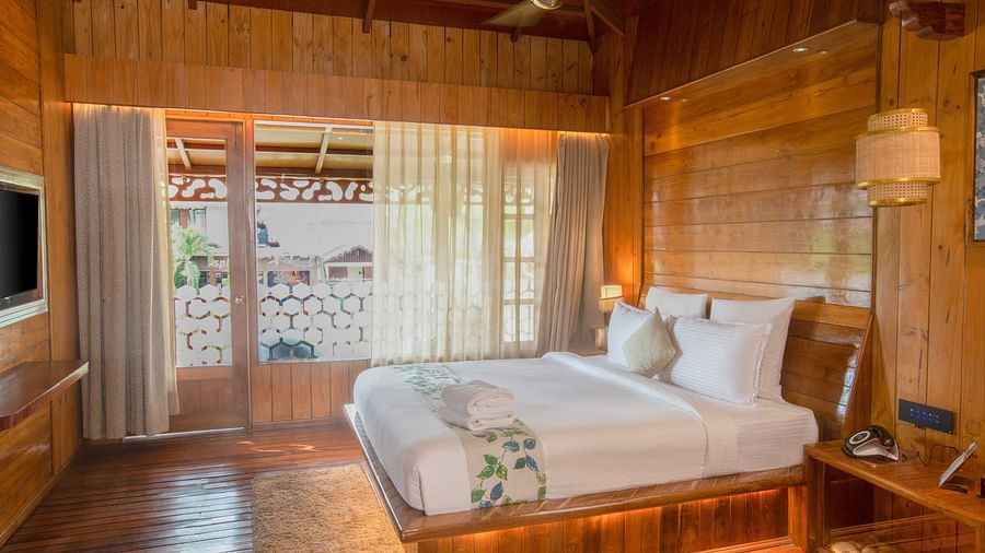 Image of Coral Turquoise at Coral Reef Resort and Spa in Havelock featuring a plush bed on the wooden furnished floor next to the door to the balcony