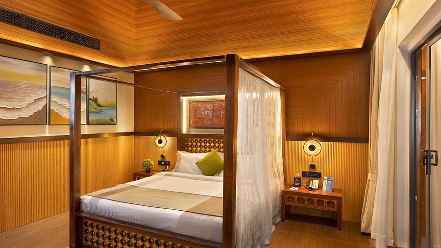 Coral Teal Suite at Coral Reef Resort and Spa in Havelock featuring a plush canopy bed with a nightstand next to it and a lamp over it