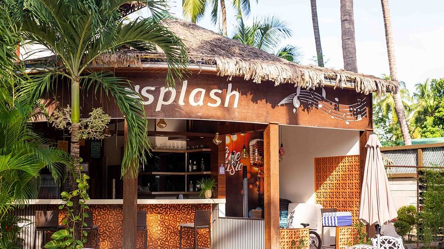A small outdoor cafe named Splash, with a thatched roof and surrounded by tropical plants. The cafe provides a relaxed setting with outdoor seating - Coral Reef Resort & Spa, Havelock