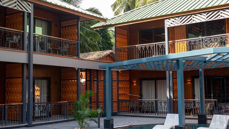  A modern resort building with multiple levels, featuring sleek architectural lines and surrounded by palm trees and greenery. The space looks inviting and serene - Coral Reef Resort & Spa, Havelock