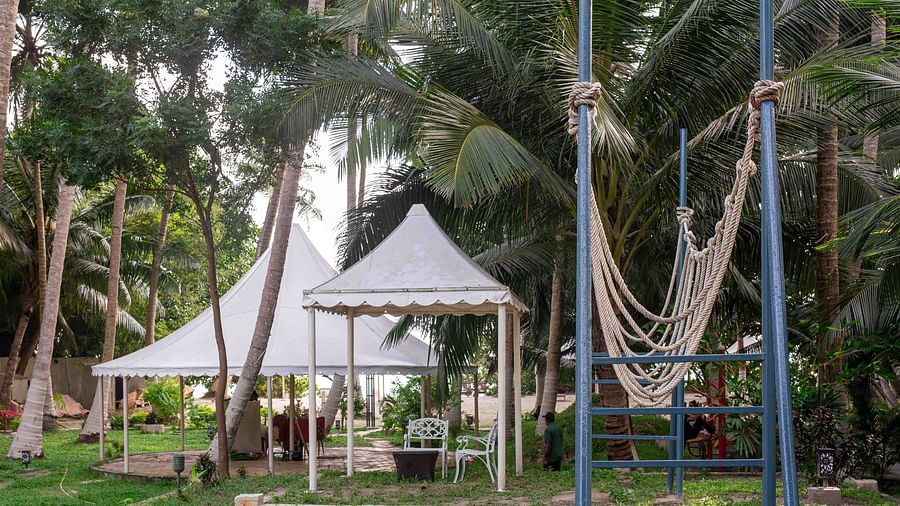 A white canopy structure surrounded by trees and tropical plants, offering an open space for relaxation or events. The setting exudes a peaceful, natural vibe - Coral Reef Resort & Spa, Havelock
