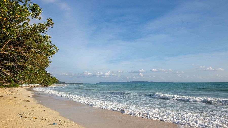 A stunning view of the beach with soft waves rolling onto the shore and a beautiful horizon. The bright sunlight and clear skies add to the peacefulness of the scene - Coral Reef Resort & Spa, Havelock