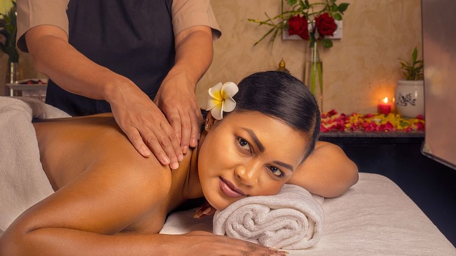 A close-up of a woman enjoying a relaxing massage in a peaceful spa setting. The warm lighting and delicate flowers around her enhance the calming atmosphere - Coral Reef Resort & Spa, Havelock