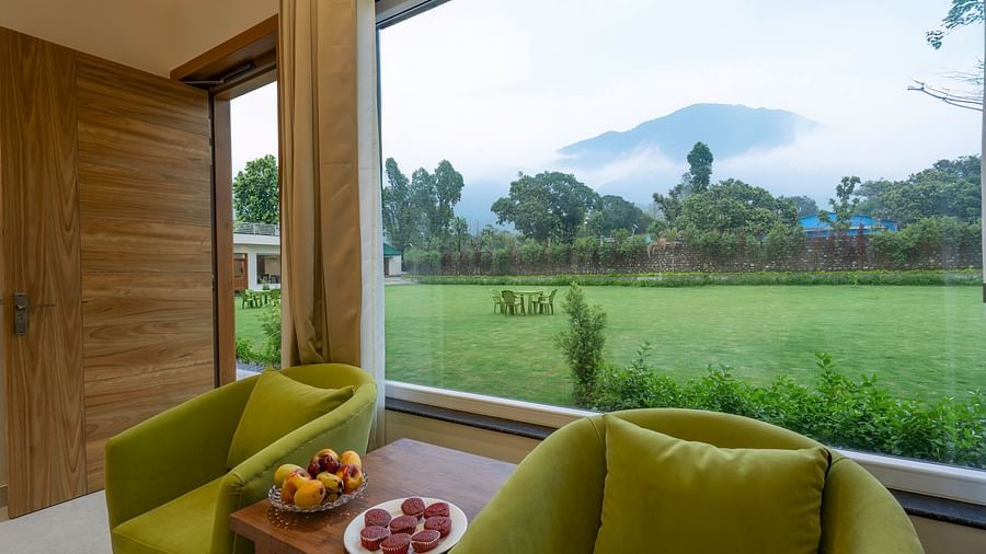 chairs and a coffee table in the mountain view room at Corbett Four Seasons, Ramnagar