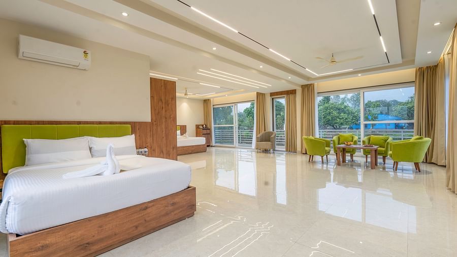 view of a king size bed and the seating area in the suite at Corbett Four Seasons, Ramnagar