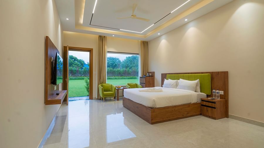 view of the lush lawn from the luxury room with bathtub at Corbett Four Seasons, Ramnagar