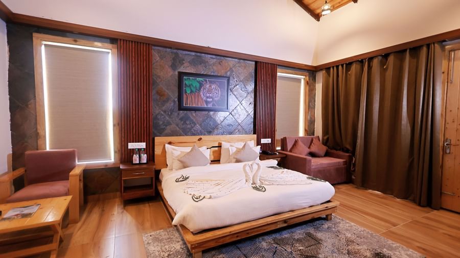 Elegant bedroom with plush bedding, warm tones, and chic decor at Corbett Nirvana Resort.