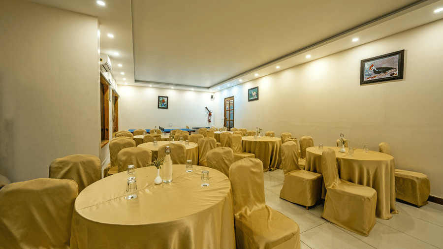 Banquet Hall at Corbett Nirvana Resort featuring several sets of tables and chairs in a classroom setting.