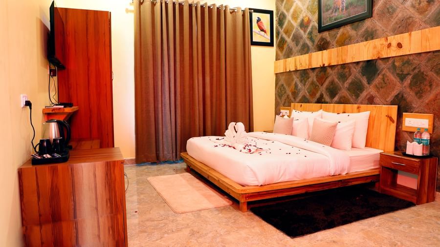 Elegant suite featuring a king size bed, warm lighting, and cosy interiors at Corbett Nirvana Resort.