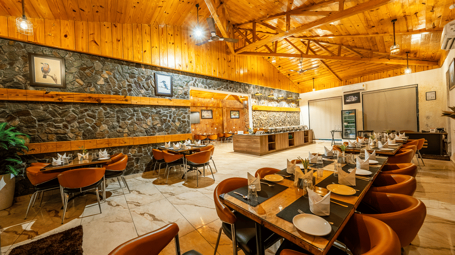 Corbett Nirvana Resort featuring a dining hall showing long tables and chairs arranged for a group under a timber ceiling.