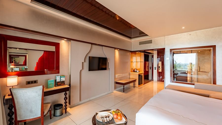 Executive Room features a spacious bed, a study table with a chair, a wall-mounted television at Crescent Spa & Resort, Indore