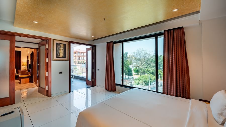Family Suite features a spacious bed and large windows showcasing the view at Crescent Spa & Resort, Indore