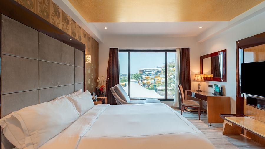 Family Suite includes a spacious bed, large windows, and a wall-mounted television at Crescent Spa & Resort, Indore