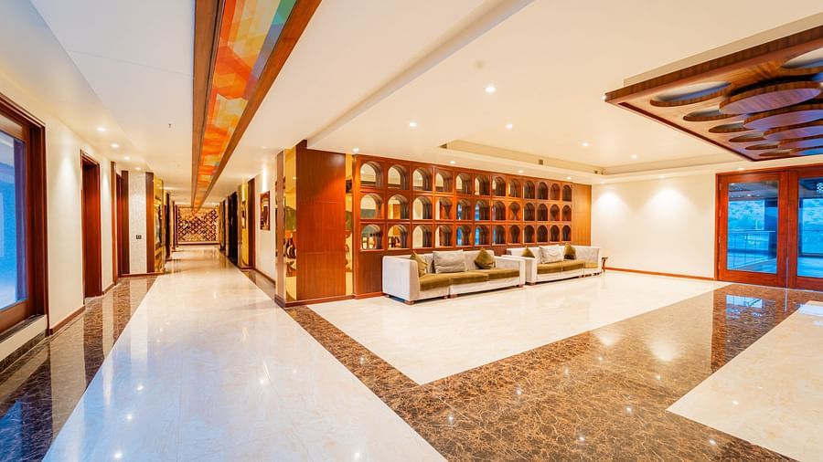 obby area with a sleek tiled floor, warm lighting, and large, comfortable furniture at Crescent Spa & Resort, Indore