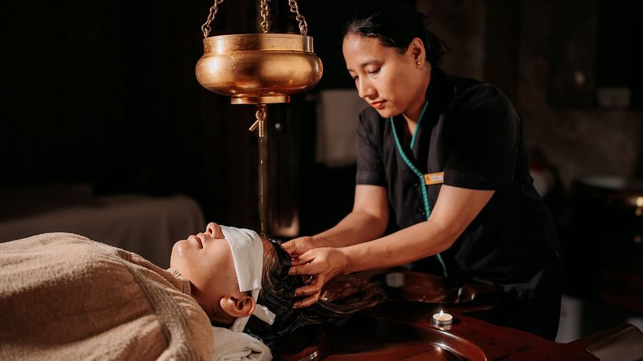 At Crescent spa & resort, Indore, a woman provides a relaxing oil massage to a guest resting on the spa bed