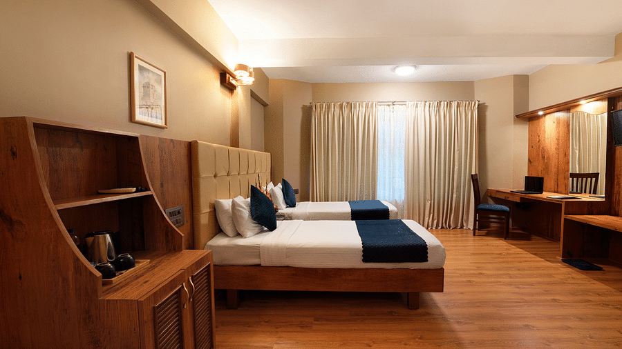 A spacious Executive Room with twin beds and a work desk - Cross Roads Inn, Bengaluru