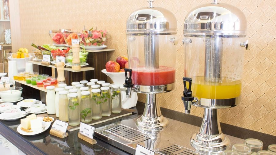 A close-up of a breakfast buffet with various dishes in chafing dishes | Daksh The Madhuvan Suites