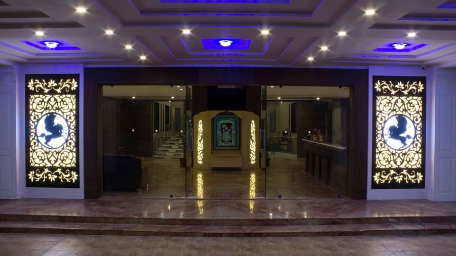 A hotel entrance with grand doors and blue-lit ceilings | Daksh The Madhuvan Suites