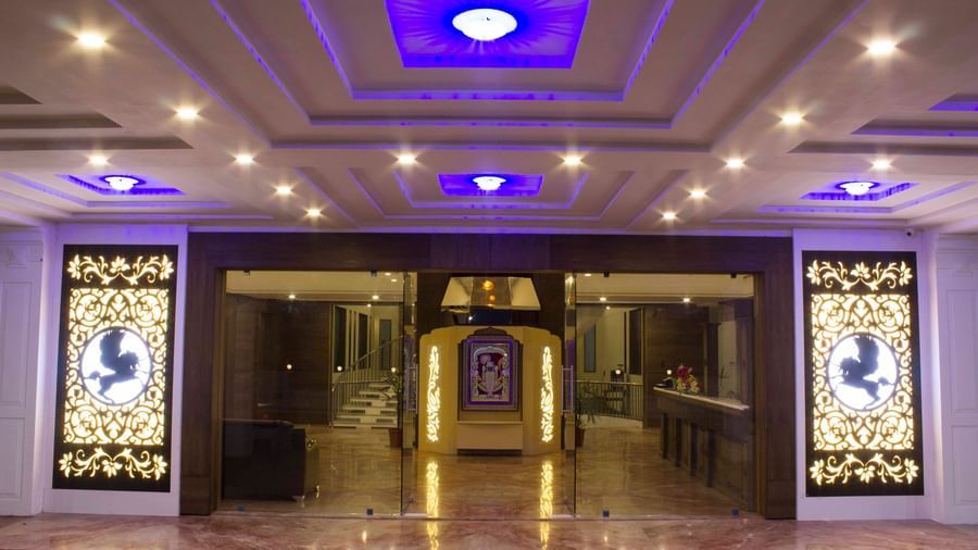 A hotel entrance with grand doors and blue-lit ceilings | Daksh The Madhuvan Suites