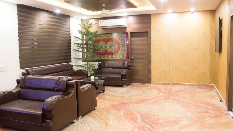  A cozy hotel lounge area with leather sofas and a plant | Daksh The Madhuvan Suites