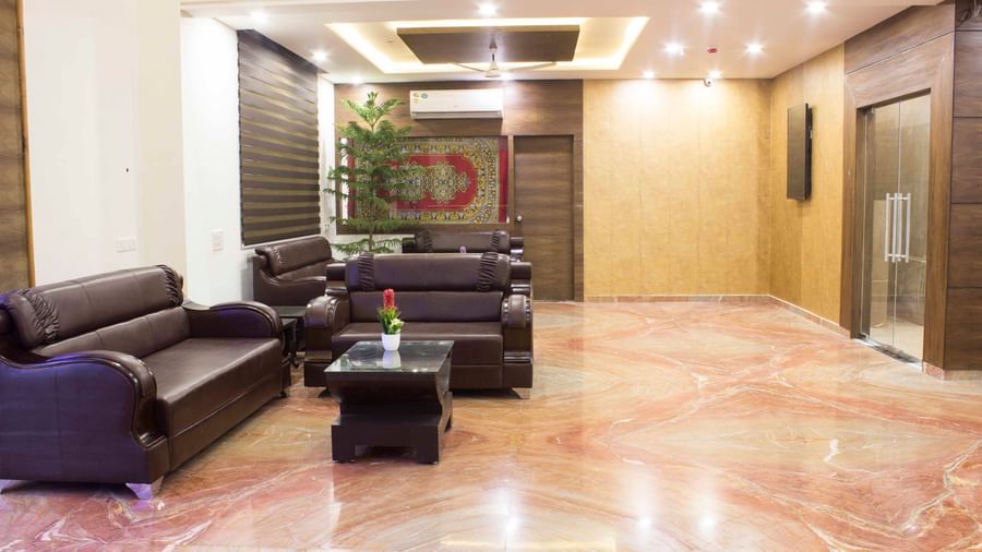 A hotel lobby with marble flooring and an elevator area | Daksh The Madhuvan Suites