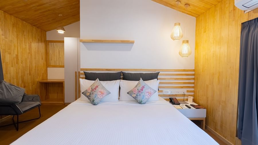 front view image of the double bed in the premium room with a modern light hanging from the ceiling - Darza Resorts