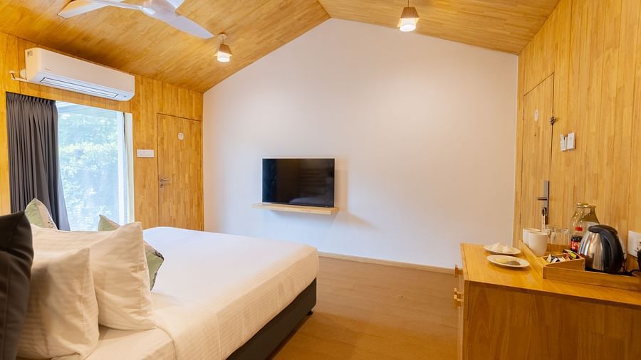 image of the premium room featuring an empty wall with a television placed right opposite to the bed - Darza Resorts