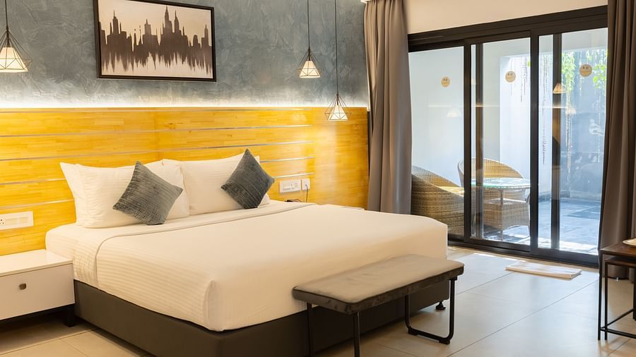 image of the garden view room featuring a plush king size bed with huge french windows in the corner - Darza Resorts