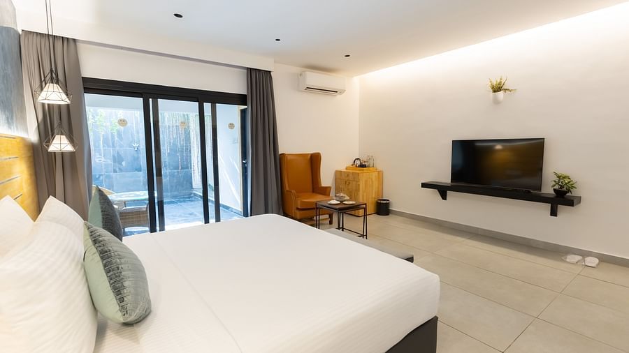 image featuring a double bed along with a wall mounted television placed across it - Darza Resorts