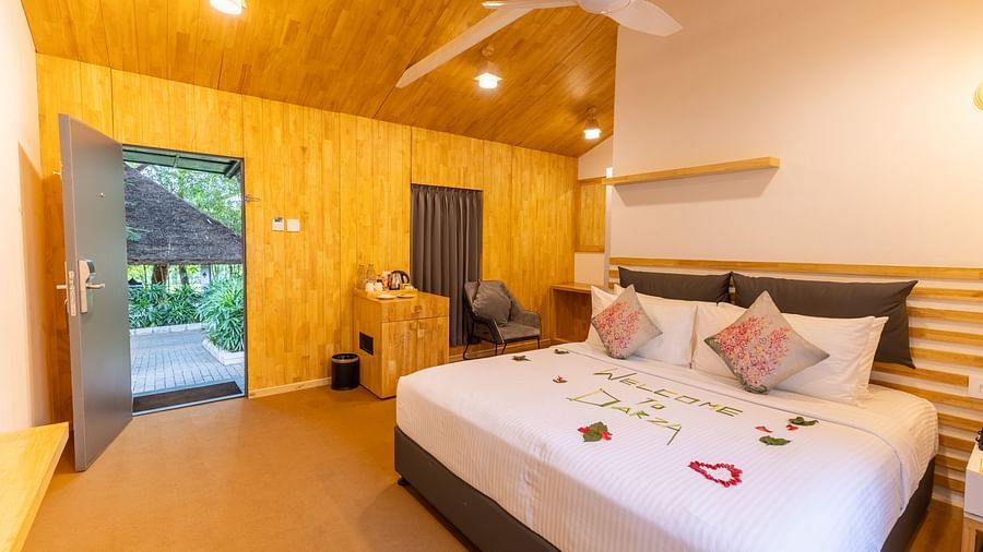 corner view of the premium room featuring a double bed with flower petals spread over it - Darza Resorts