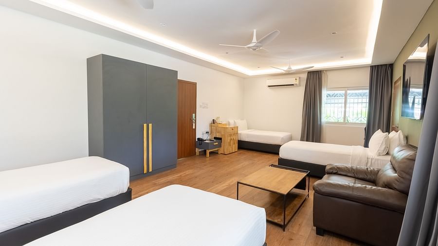 corner view image of a bedroom with all four single beds along with a huge wardrobe in the luxury group stay villa - Darza Resorts