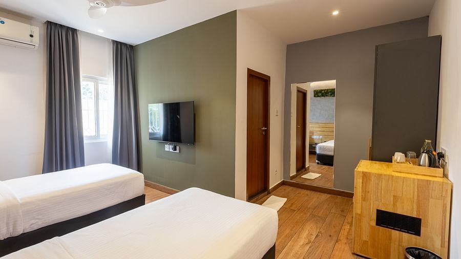 image of a bedroom with a twin bed along with a full length mirror at the luxury group stay villa - Darza Resorts