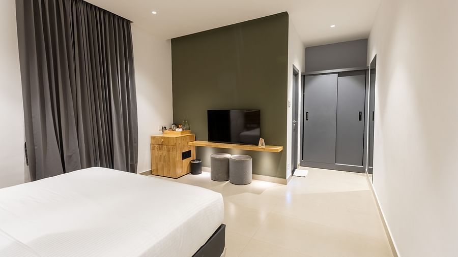 image of a bedroom featuring a tv placed opposite a double bed at the luxury group stay villa - Darza Resorts