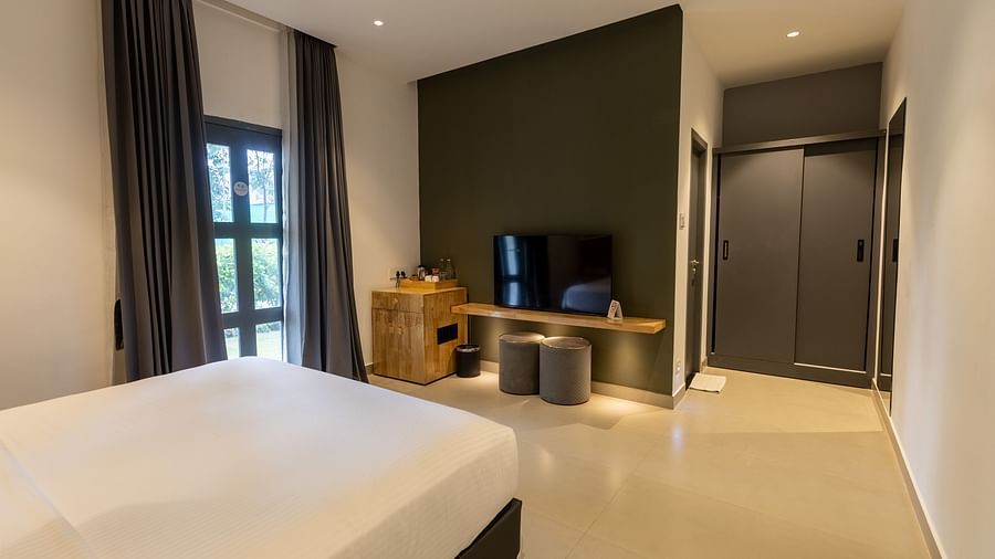 image of a bedroom featuring a tv placed opposite a double bed at the luxury group stay villa - Darza Resorts