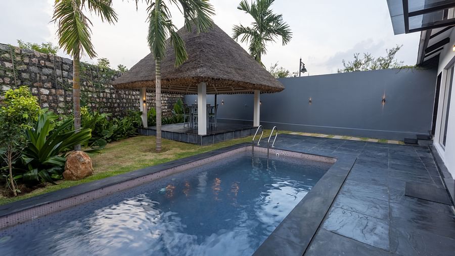 image featuring a swimming pool along with a hut like structure with beautiful cloudy sky in the background at the luxury villa - Darza Resorts