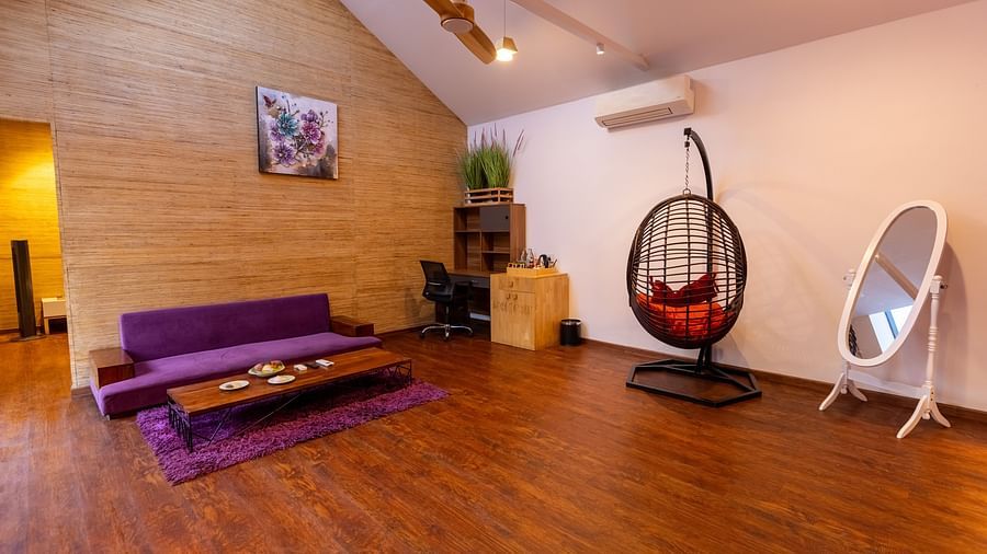 full view image of the living room featuring a couch with a swing and a full length mirror at the luxury villa - Darza Resorts